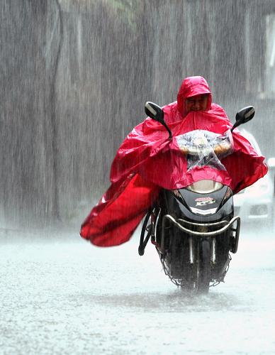 7月13日,一名男子在雨中的武漢街頭騎行。當(dāng)日,湖北省武漢市遭受大暴雨襲擊,城區(qū)多處地段嚴(yán)重積水,被網(wǎng)友戲稱(chēng)為“城區(qū)可‘看海’。” 新華社發(fā)
