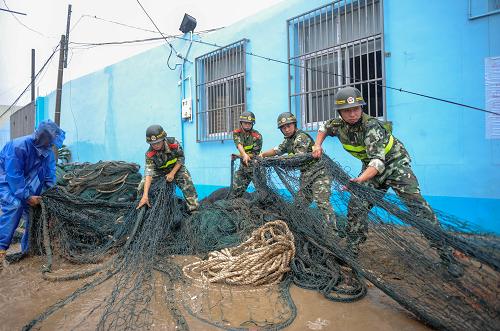 8月2日,在浙江最南部、浙閩交界的蒼南縣馬站鎮(zhèn),邊防官兵幫助一位漁民收起漁網(wǎng)。 浙江省防汛抗旱指揮部2日16時(shí)30分決定啟動(dòng)防臺(tái)風(fēng)應(yīng)急響應(yīng)由Ⅱ級提升為Ⅰ級,為防臺(tái)風(fēng)的最高應(yīng)急等級。據(jù)介紹,目前浙江各地已經(jīng)根據(jù)情況及時(shí)啟動(dòng)防臺(tái)風(fēng)應(yīng)急響應(yīng),全力做好各項(xiàng)防御工作,嚴(yán)陣以待,積極應(yīng)對臺(tái)風(fēng)“蘇拉”。 新華社記者韓傳號攝