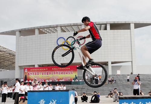 8月5日,在山東省滕州市體育中心五環(huán)廣場(chǎng),一名自行車(chē)愛(ài)好者在表演自行車(chē)特技。 新華社發(fā)(宋海存 攝)