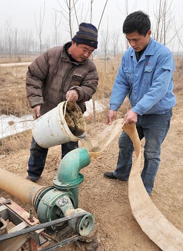 2月7日,河北省新河縣南馮村農(nóng)民楊奎斌(左)在灌泵,準(zhǔn)備抽水澆地。新華社記者 楊世堯 攝