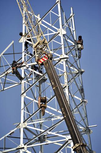 3月4日,國家電網(wǎng)天津高壓供電公司員工在京滬高速鐵路天津段豆張莊電源線組塔進行施工作業(yè)。 新華社記者 劉海峰 攝