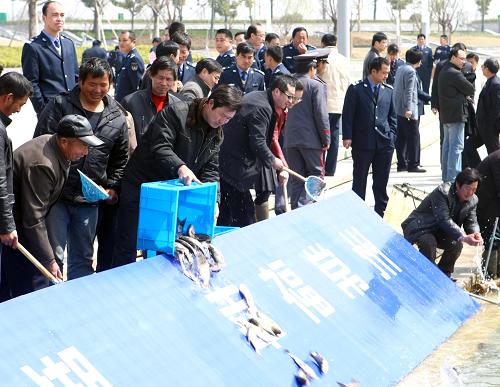 3月25日,江蘇省常州市的市民代表在滆湖邊投放魚(yú)苗。新華社發(fā)(胡平 攝)