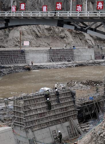 4月4日,工人在舟曲白龍江堤防建設(shè)工地上施工。新華社記者 聶建江 攝