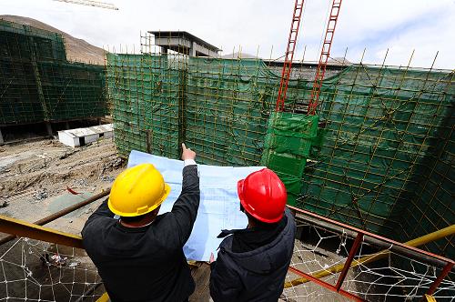 4月10日,中鐵二局兩名施工人員在青海省玉樹藏族自治州玉樹縣第一民族中學(xué)新址施工點(diǎn)討論施工方案。新華社記者 張宏祥 攝