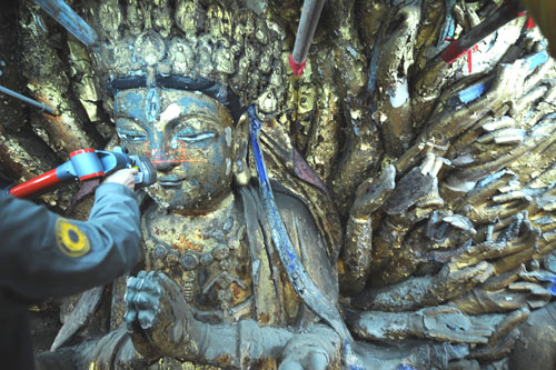 4月18日,一位技術(shù)人員正在對(duì)千手觀音造像進(jìn)行激光掃描。當(dāng)日,大足石刻千手觀音造像搶救性保護(hù)工程正式啟動(dòng)。專家表示將最大限度地保持千手觀音的歷史價(jià)值、藝術(shù)價(jià)值和科學(xué)價(jià)值。始建于唐、興盛于兩宋的重慶大足石刻有5萬多尊造像,1999年被列入世界遺產(chǎn)名錄,代表了公元9世紀(jì)至13世紀(jì)世界石窟藝術(shù)的最高水平。千手觀音造像雕鑿于南宋中后期,在88平方米的崖面上刻有近千只手、眼及多種法器,集雕塑、彩繪、貼金于一體,狀如孔雀開屏,斑斕奪目。新華社記者 周衡義 攝