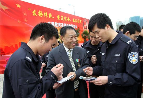 4月30日,全國(guó)勞動(dòng)模范馬桂寧(中)為新民警贈(zèng)言。新華社記者 凡軍 攝