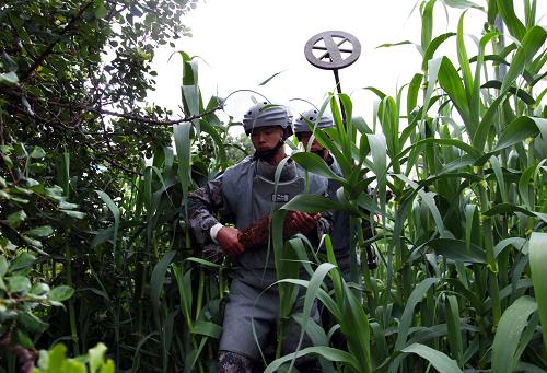 5月13日,在黎巴嫩與以色列邊界黎巴嫩一側(cè),中國第八批赴黎巴嫩維和工兵營的排爆手轉(zhuǎn)移拆除引信后的炮彈。中國第八批赴黎巴嫩維和工兵當日在黎以邊界黎巴嫩一側(cè)成功清排一枚未爆炮彈。中國第八批赴黎維和工兵營自2011年3月底開始在“藍線”地區(qū)掃雷以來,60名掃雷官兵在五條通道平行展開作業(yè),截至目前共清排雷場區(qū)域530多平方米,銷毀地雷30枚。第八批赴黎巴嫩維和工兵營下轄掃雷排爆連、工程建筑連、工程維護連和勤務(wù)保障連等,他們被部署在黎巴嫩南部地區(qū),在緊鄰以色列的“藍線”附近執(zhí)行為期8個月的掃雷排爆、修建公路、構(gòu)筑工事、勘定邊界、戰(zhàn)后重建和人道主義救援等任務(wù)。新華社發(fā)(王艷波攝)