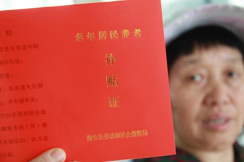 6月2日,在江蘇南通海安縣職工社會養(yǎng)老保險基金管理中心,一名老人展示自己的《老年居民養(yǎng)老補貼證》。新華社 發(fā)