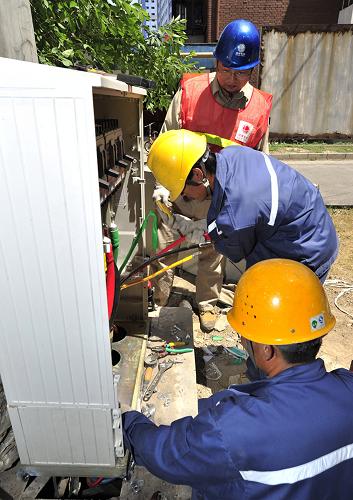 6月3日,國(guó)家電網(wǎng)天津城西供電分公司配電施工人員在南開(kāi)區(qū)府湖里居民小區(qū)進(jìn)行低壓開(kāi)關(guān)柜升級(jí)改造。新華社發(fā)(吳宣述 攝)