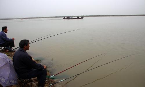 6月5日,市民在漲水的鄱陽湖都昌港口附近釣魚。新華社發(fā)(傅建斌 攝)