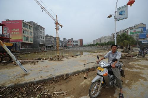 望謨縣城內(nèi)一處地勢(shì)較低的工地變?yōu)橐粋€(gè)大水坑(6月7日攝)。新華社記者 劉續(xù) 攝