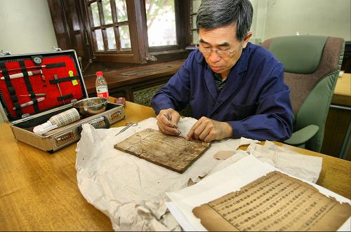 6月8日,國家圖書館工作人員在中華典籍與非物質(zhì)文化遺產(chǎn)特展上演示古籍修復(fù)過程。新華社發(fā)(趙冰 攝)