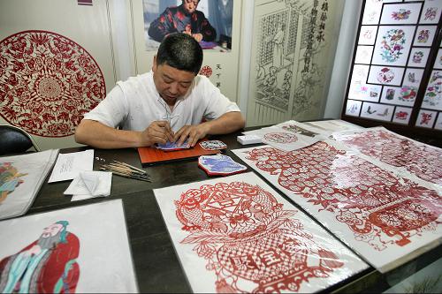 6月8日,蔚縣剪紙傳承人高佃亮在中華典籍與非物質(zhì)文化遺產(chǎn)特展上進行剪紙創(chuàng)作。新華社發(fā)(趙冰 攝)