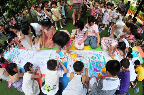 6月8日,四川省南充市順慶區(qū)金紅國際幼稚園的小朋友在長卷上作畫,描繪心中的海洋。新華社發(fā)(李向雨 攝)