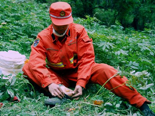6月8日,在甘肅連城自然保護區(qū)森林火災(zāi)3號火點,一名森林武警部隊滅火隊員在處理腳上燙出的水泡。新華社記者 高健鈞 攝