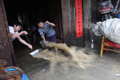 6月10日,湖南省婁底市新化縣西河鎮(zhèn)沙江村村民在清理屋內(nèi)積水。新華社發(fā)(郭國權(quán) 攝)