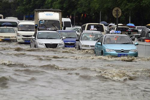 6月18日,強(qiáng)降雨襲擊武漢,汽車(chē)在積水中“破浪”前行。新華社發(fā)(李理 攝)