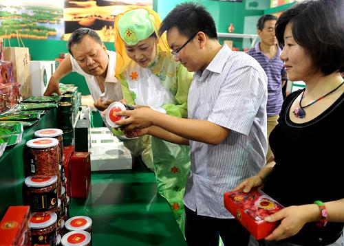 6月24日,在2011中國國際旅游商品博覽會(huì)寧夏展區(qū),工作人員向客商介紹當(dāng)?shù)靥禺a(chǎn)。新華社發(fā)(張建成 攝)