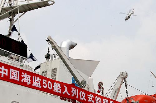 7月23日,一架“直9”艦載直升機停正從“中國海監(jiān)50”船上方飛過。新華社記者 陳飛 攝