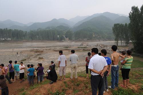 欒川縣潭頭鎮(zhèn)村民在垮塌的大橋前守望(2010年7月27日攝)。2010年7月24日,河南省欒川縣遭遇特大洪澇災(zāi)害,全縣受災(zāi)人口高達(dá)48%,因?yàn)?zāi)直接經(jīng)濟(jì)損失約19.8億元。一年來,欒川縣已累計(jì)投入資金15億多元,完成重點(diǎn)河壩修復(fù)172.9公里,重點(diǎn)河段疏浚19.5公里,全縣1494戶房屋倒塌戶全部住進(jìn)了新房,當(dāng)?shù)厮畾Ч坊拘迯?fù)完畢。目前,災(zāi)后重建工作仍在繼續(xù)。新華社記者 趙鵬攝