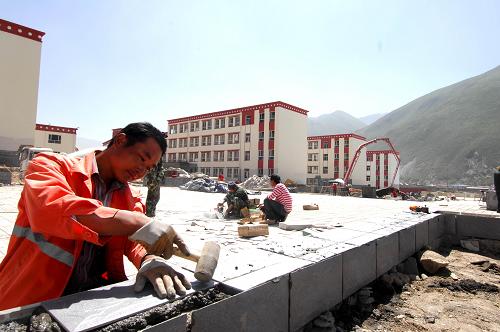8月9日,一名中國鐵建工人在玉樹州民族中學(xué)內(nèi)為新校舍貼瓷磚。根據(jù)青海省玉樹地震災(zāi)后重建工作領(lǐng)導(dǎo)小組的安排,2011年玉樹重建將投入資金200億元,擬安排項目798項,涵蓋城鄉(xiāng)居民住房、基礎(chǔ)設(shè)施、公共服務(wù)設(shè)施、和諧家園、特色產(chǎn)業(yè)、生態(tài)環(huán)境、征地拆遷等7個方面。截至7月底,玉樹災(zāi)后重建已累計開工建設(shè)413個項目,年內(nèi)將力爭完成全部重建項目規(guī)劃設(shè)計和農(nóng)村住房重建,完成大部分城鎮(zhèn)住房重建,開工建設(shè)大部分公共服務(wù)設(shè)施和基礎(chǔ)設(shè)施項目,形成150億元的實物量。新華社記者 吳光于 攝