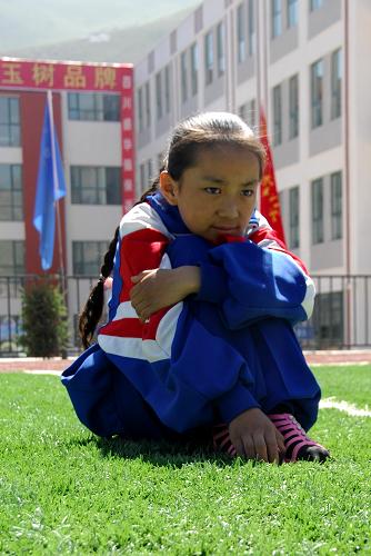 8月11日,玉樹縣第二完全小學五年級學生卓瑪班措坐在學校的操場上。新華社記者 吳光于 攝