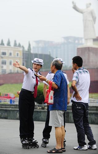 8月10日,輪滑城管勸導(dǎo)隊員李吉(左一)給問路人指路。新華社記者 江宏景 攝
