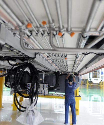 8月12日,長春軌道客車股份有限公司工作人員在總組裝間進(jìn)行零部件組裝工作。新華社記者 林宏 攝