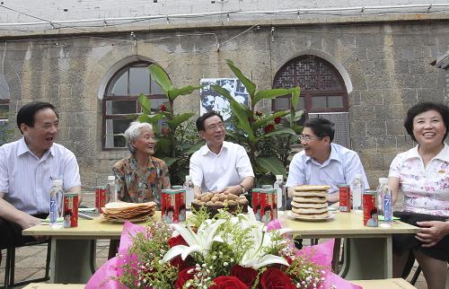 這是8月12日,賀國強(qiáng)在晉中市昔陽縣大寨村80歲的勞動模范宋立英家的小院里,與老人及當(dāng)?shù)馗刹咳罕娪H切攀談。新華社記者 丁林 攝