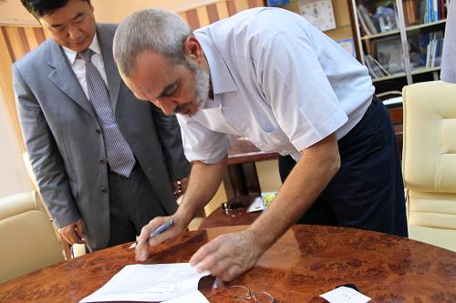 8月20日,在利比亞班加西,利比亞“全國過渡委員會”人道主義救援委員會主席哈立德·穆罕默德在物資確認書上簽字,中國駐埃及大使館公使銜參贊馬建春(左)出席了有關(guān)救援物資的會談。新華社記者 王洪江 攝