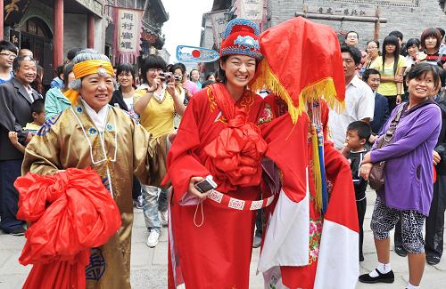9月11日,游客扮成新人在山東淄博周村古商城內(nèi)準備“成親”。中秋節(jié)期間,山東淄博周村古商城開展古婚俗體驗活動,游客扮成新人體驗古代婚禮風俗,快樂過中秋。新華社發(fā)(董乃德 攝)