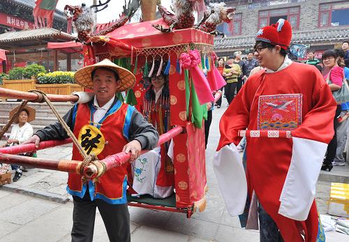 9月11日,游客扮成新人在山東淄博周村古商城內(nèi)乘坐花轎。新華社發(fā)(董乃德 攝)