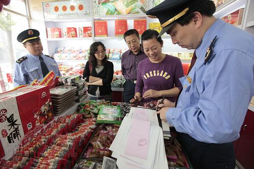 9月27日,北京東城工商分局工作人員在一家商店內(nèi)核查北京特產(chǎn)果脯的進(jìn)貨渠道。當(dāng)日,北京市東城區(qū)食品辦組織監(jiān)察局、工商分局、衛(wèi)生局等部門,對(duì)轄區(qū)旅游景點(diǎn)周邊的餐館、工地食堂和食品店進(jìn)行檢查,確保節(jié)日市場(chǎng)的食品安全。新華社發(fā)(羅偉 攝)