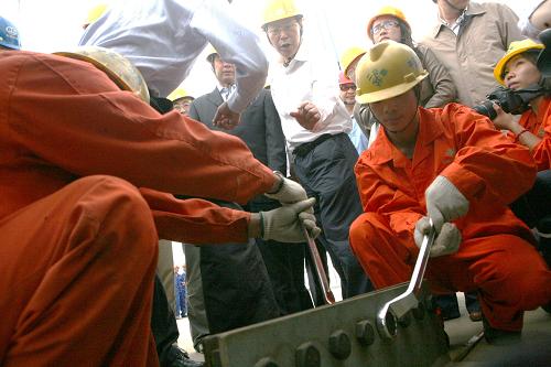 9月28日,在江蘇泰州長江大橋施工現(xiàn)場,工人們擰緊最后一顆螺母,大橋順利合龍。經(jīng)過4個(gè)多月的吊裝施工,9月28日,江蘇泰州長江大橋鋼箱梁全部到位,實(shí)現(xiàn)全線合龍,初步形成一個(gè)完整的橋面。建設(shè)中的泰州長江大橋全長62公里,是世界首座三塔兩跨懸索橋,預(yù)計(jì)2011年年底建成。 新華社發(fā)(顧俊 攝)