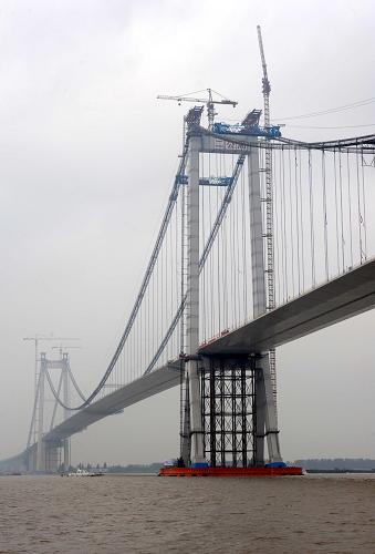 9月28日,位于泰州大橋中塔(右)北側(cè)的最后一塊鋼箱梁(圖中橋塔右側(cè))正在吊裝到位。新華社記者 孫參 攝