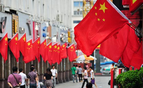 9月29日,在廣西南寧市民生路,市民從國(guó)旗高掛的步行街上走過(guò)。國(guó)慶節(jié)臨近,五彩繽紛的鮮花、紅旗等把壯鄉(xiāng)首府廣西南寧裝扮一新,營(yíng)造祥和、喜慶的節(jié)日氛圍。新華社發(fā)(陸波岸 攝)