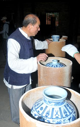 10月23日,在江西省景德鎮(zhèn)古窯民俗博覽區(qū)內(nèi),把樁師傅胡家旺清點(diǎn)元代饅頭窯中復(fù)燒的瓷器。新華社發(fā)(石衛(wèi)明 攝)