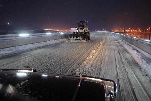 11月29日,鏟車在清理太原機(jī)場(chǎng)高速路上的積雪。新華社記者 范敏達(dá) 攝