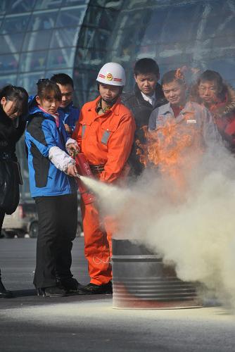 12月11日,消防人員在指導阜陽會展中心的工作人員使用滅火器。新華社發(fā)(蔡嘯天 攝)