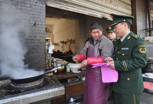 12月11日,阜陽開發(fā)區(qū)消防大隊警官在為商戶發(fā)放防火安全宣傳單。新華社發(fā)(蔡嘯天 攝)