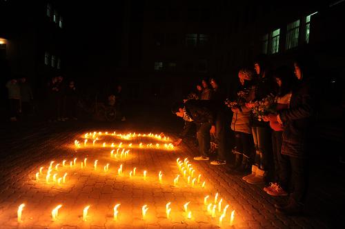12月11日晚,山東聊城大學(xué)校園內(nèi),學(xué)生們獻(xiàn)花悼念南京大屠殺30萬遇難同胞。新華社發(fā)(董光強(qiáng) 攝)