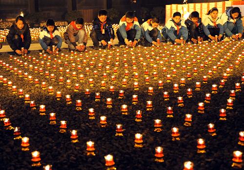 12月12日,南京小學(xué)生代表在祭場上擺放紅燭。 當(dāng)晚,來自韓國、日本等國的國際友好人士、南京市民和學(xué)生代表、中日兩國僧侶在侵華日軍南京大屠殺遇難同胞紀(jì)念館祭場點(diǎn)燃3000支紅燭,開展“平安夜——為南京大屠殺遇難者守靈暨燭光祈禱和平晚會”活動,悼念30萬遇難者。2011年12月13日,是侵華日軍南京大屠殺30萬同胞遇難74周年的祭日。 新華社記者孫參攝