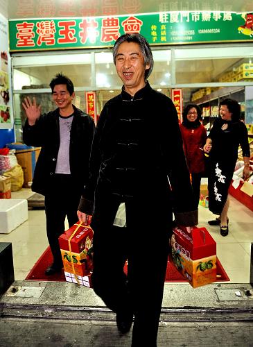 12月13日,一名來自北京的顧客(前)在廈門市中埔臺灣水果銷售集散中心選購了臺灣水果。新華社記者 張國俊 攝