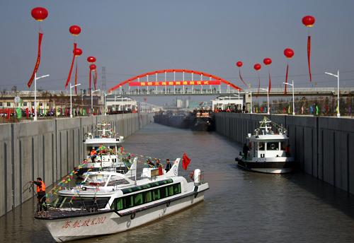 12月16日,在護(hù)航船(前)的護(hù)送下,貨運(yùn)船排隊(duì)從江蘇揚(yáng)州施橋三線船閘通過。 當(dāng)日,京杭運(yùn)河沿線最大的船閘--揚(yáng)州施橋三線船閘經(jīng)過近3年的施工,實(shí)現(xiàn)正式通航。 據(jù)介紹,除施橋船閘外,運(yùn)河揚(yáng)州段內(nèi)的另一座高等級船閘--邵伯三線船閘也在緊鑼密鼓的準(zhǔn)備之中,即將迎來放水調(diào)試。施橋、邵伯這兩座船閘正式投運(yùn)后,京杭運(yùn)河揚(yáng)州段的通行能力將提升40%以上,成為名副其實(shí)的“運(yùn)河南大門”。 新華社發(fā)(董輝 攝)