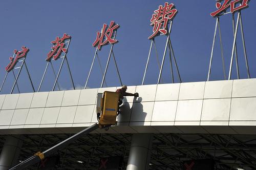 12月16日,工人在清潔崇啟大橋收費處的建筑外墻。新華社發(fā)(鄭憲章 攝)