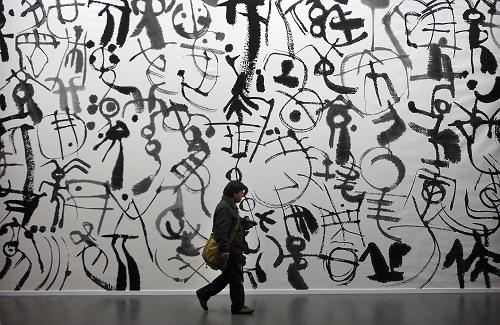 12月27日,觀眾從作品《天書》前走過(guò)。近日,韓美林藝術(shù)大展在中國(guó)國(guó)家博物館展出。此次展覽展出韓美林繪畫、書法、雕塑、陶瓷、設(shè)計(jì)等門類的新作3200余件,展覽面積6000平方米,是國(guó)家博物館百年歷史上舉辦的最大規(guī)模的個(gè)人藝術(shù)展。展覽將持續(xù)至2012年2月8日。新華社發(fā)(萬(wàn)象 攝)