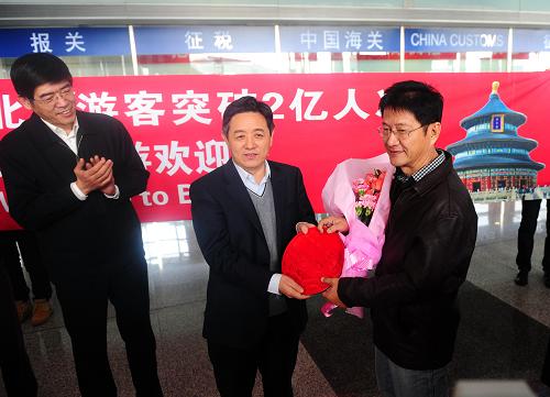 12月28日,北京市副市長丁向陽(中)向印尼游客尤利尤斯·韓(右)贈送紀念品。新華社發(fā)(馬儒壯 攝)