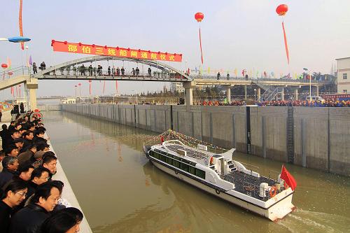 12月28日,一艘護(hù)航船從江蘇揚(yáng)州邵伯三線船閘通過(guò)。當(dāng)日,第一批船舶安全駛出剛建成的京杭運(yùn)河邵伯三線船閘。邵伯三線船閘的竣工通航,標(biāo)志著京杭運(yùn)河貨運(yùn)量最大、船舶運(yùn)輸最繁忙、經(jīng)濟(jì)社會(huì)效益最顯著的蘇北段船閘擴(kuò)容工程全部完工。自此,京杭運(yùn)河蘇北段的整體通航能力提升了50%以上。新華社發(fā)(郁興 攝)