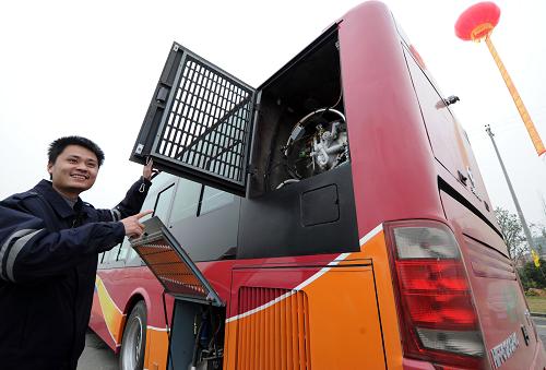 12月28日,在廣西桂林天然氣公交車首發(fā)儀式現(xiàn)場,公交車司機展示汽車尾部的天然氣儲氣罐。新華社發(fā)(唐艷蘭 攝)