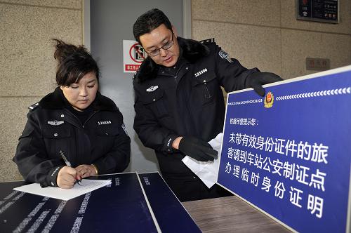 1月7日,銀川鐵路公安處民警在“制證點”擺放臨時身份證辦理引導(dǎo)牌。 近日,為配合2012年春運火車實名制購票的推行,寧夏銀川市鐵路公安處在銀川火車站設(shè)立“制證點”為旅客辦理臨時身份證。取票、購票時遺失身份證的旅客只需本人攜帶照片,提供本人遺失身份證相關(guān)信息,經(jīng)網(wǎng)上審核、身份比對后即可在5分鐘內(nèi)拿到有效期為一天的臨時身份證。“制證點”的設(shè)立極大方便了旅客出行,并有力保障實名制購票的推行。 新華社記者 王鵬 攝